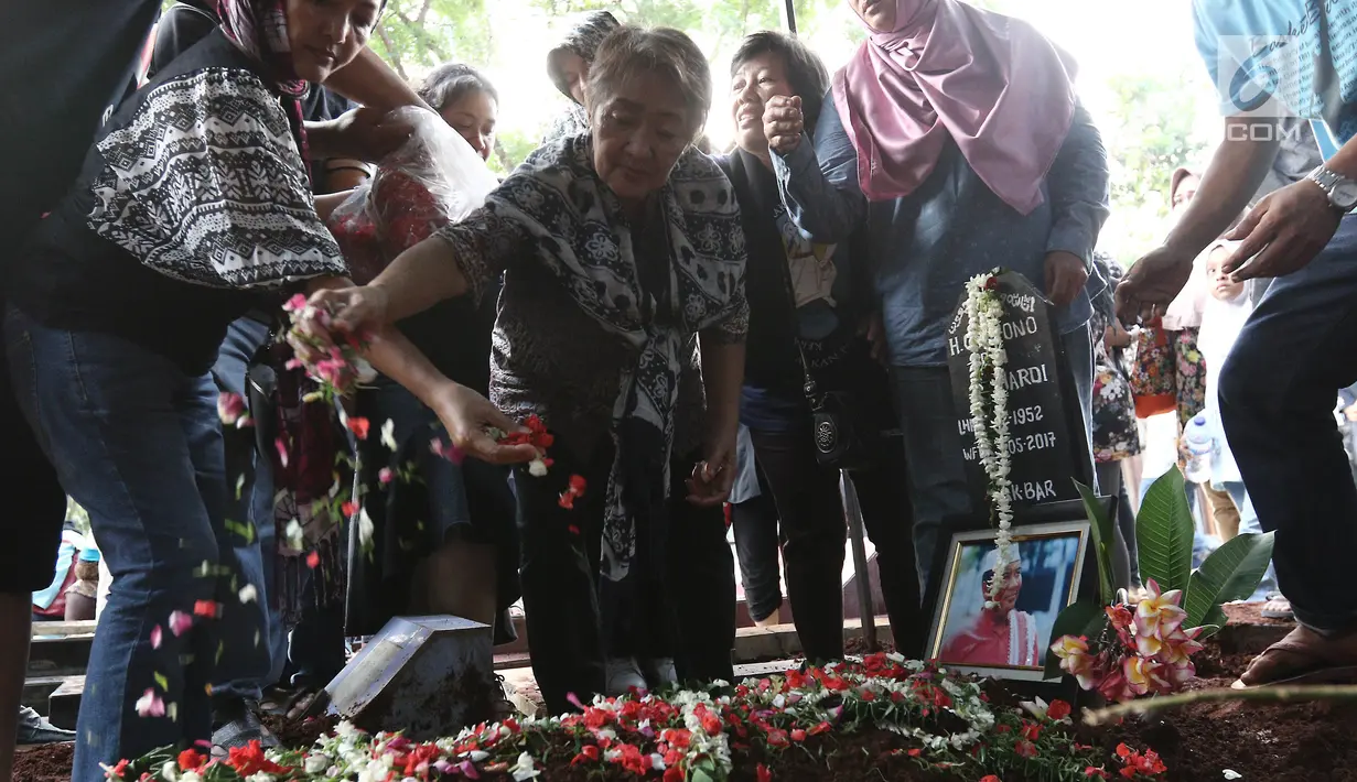 Penaburan bunga di atas makam Pelawak Senior Cahyono di TPU Komplek TVRI, Jakarta, Kamis (25/5). Cahyono meninggal karena menderita komplikasi serangan jantung dan diabetes. (Liputan6.com/Herman Zakharia)