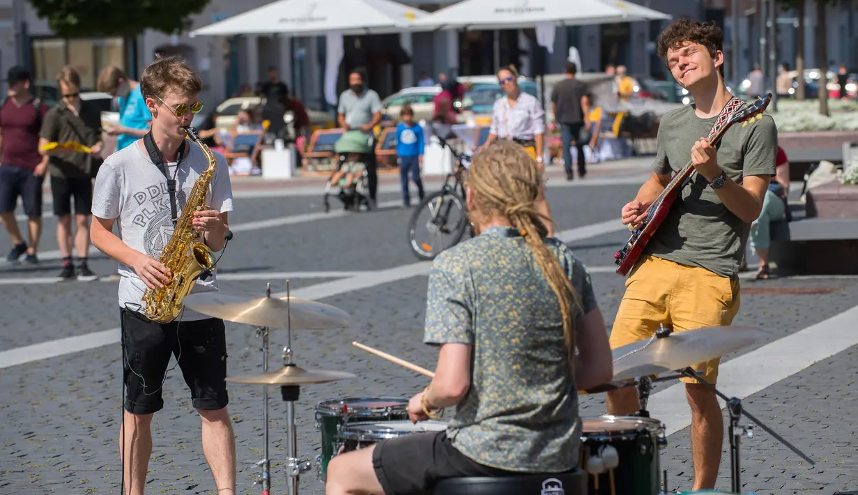 Orang-orang tampil di acara Hari Musik Jalanan (Street Music Day) di Vilnius, Lithuania (18/7/2020). Sejumlah musisi profesional dan amatir tampil di jalan-jalan dan taman di kota tua Vilnius dalam rangka merayakan Hari Musik Jalanan pada Sabtu (18/7). (Xinhua/Alfredas Pliadis)