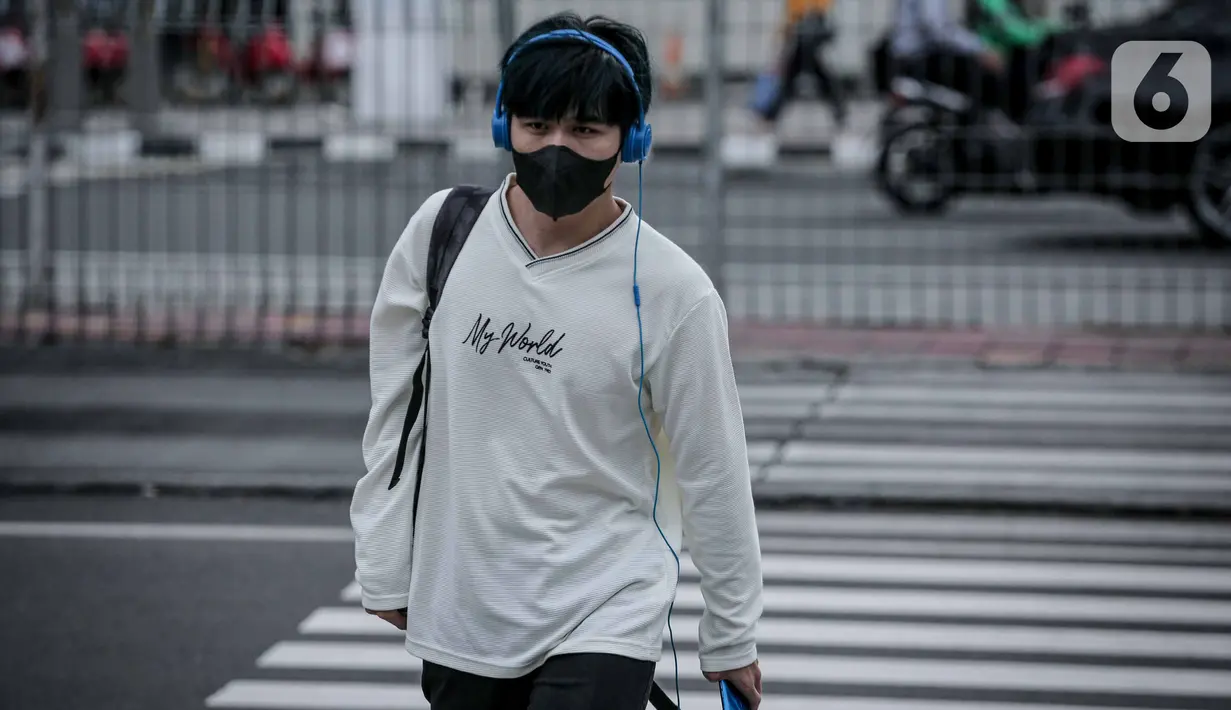 Seorang pria berjalan di Kawasan Sudirman, Jakarta, Kamis, (17/2/2022). Kepala BPBD DKI Jakarta Isnawa Adji mengatakan, Menteri Kesehatan (Menkes) Budi Gunadi Sadikin sudah memberikan sinyal bahwa DKI telah melewati pandemi gelombang ketiga. (Liputan6.com/Faizal Fanani)