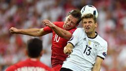 Pemain Jerman, Thomas Muller, duel dengan pemain Polandia, Grzegorz Krychowiak, pada laga kedua Grup C Piala Eropa 2016 di Stade de France, Jumat (17/6/2016) dini hari WIB. (AFP/Patrik Stollarz)