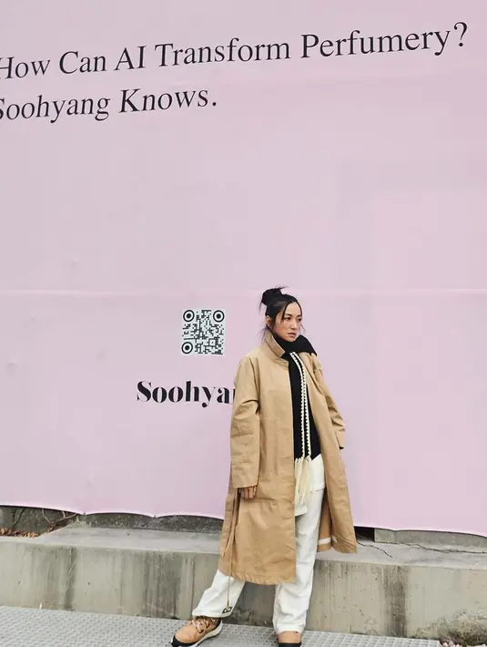 Hesti tampil kasual dengan inner berwarna hitam, ditmpuknya dengan long coat berwarna cokelat, dan celana panjang berwarna putih. [Foto: Instagram/hestipurwadinata]