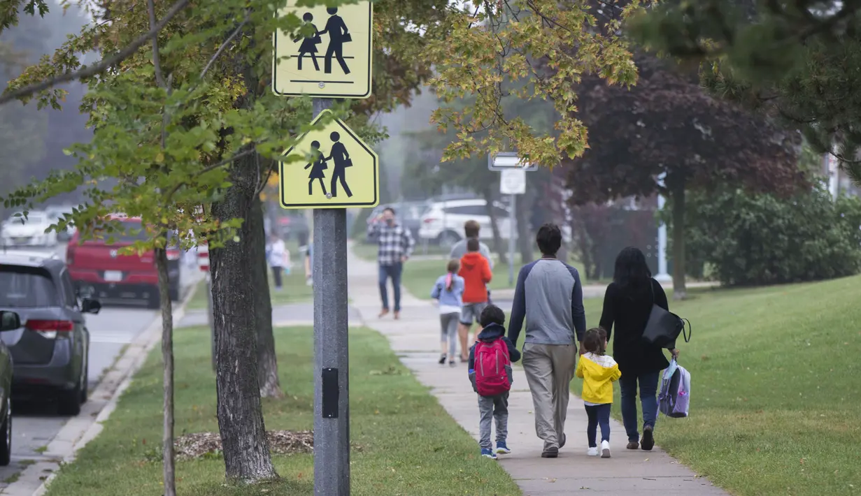 Para murid dan orang tuanya tiba di sebuah sekolah di Mississauga, Ontario, Kanada (9/9/2020). Beberapa sekolah di Ontario dibuka kembali pada Rabu (9/9), menawarkan kombinasi kelas tatap muka dan pembelajaran daring (online) bagi para murid. (Xinhua/Zou Zheng)