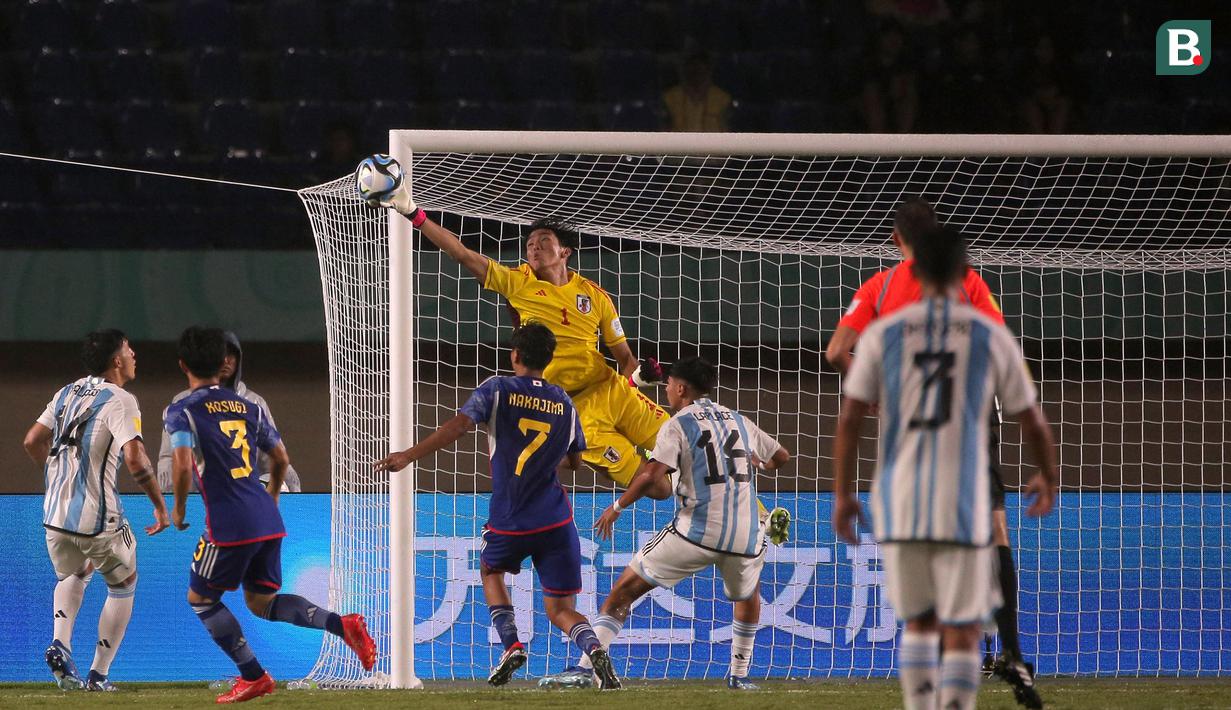 <p>Kiper Timnas Jepang U-17, Wataru Goto (tengah) terbang untuk menepis bola saat menghadapi Timnas Argentina U-17 pada laga kedua Grup D Piala Dunia U-17 2023 di Stadion Si Jalak Harupat, Kabupaten Bandung, Selasa (14/11/2023). (Bola.com/Ikhwan Yanuar)</p>