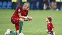 Bek Timnas Portugal, Pepe berbincang dengan sang buah hati usai membawa negaranya ke babak semi final Piala Eropa 2016. Pepe menjadi satu di antara kunci keberhasilan Seleccao mengalahkan Polandia, di Stade Velodrome, Jumat (1/7/2016) dini hari WIB.  (Reu