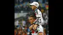 Pemain depan Timnas Jerman, Lukas Podolski, menggendong anaknya, Louis Gabriel Podolski, setelah memenangkan final Piala Dunia 2014 kontra Argentina di Stadion Maracana, Rio de Janeiro, (14/7/2014). (REUTERS/Kai Pfaffenbach)