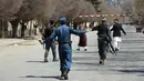 Pasukan keamanan memblokir jalan di lokasi serangan bunuh diri di depan Universitas Kabul, Afghanistan, (21/3). Pejabat Afghanistan melaporkan ledakan tersebut di saat warga merayakan Tahun Baru Persia. (AP Photo/Rahmat Gul)