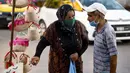 Perempuan Tunisia yang mengenakan masker berbincang dengan seorang penjual di sebuah pasar ketika kasus baru infeksi Corona melonjak, di kota Gabes, Rabu (27/8/2020). Tunisia pada 25 Agustus 2020 melaporkan peningkatan tertinggi kasus baru Covid-19 dibandingkan minggu sebelumnya. (FETHI BELAID/AFP)