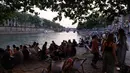 Orang-orang berbincang saat berkumpul di tepi sungai Seine sebagai bagian dari acara musim panas Paris Plages di Paris, Prancis (7/7). (AFP Photo/Francois Guillot)