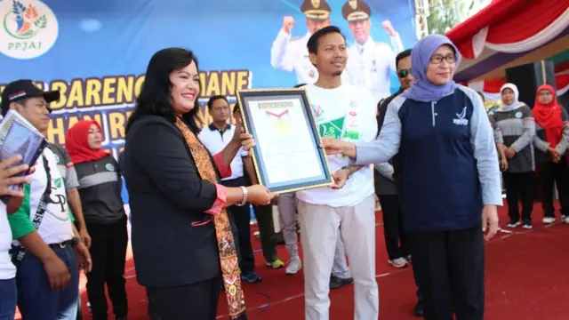 Manajer Senior MURI Sri Widayati menyerahkan piagam rekor Muri kepada Ketua PPJAI Mukit Hendrayanto didampingi Kepala Balai BPOM Semarang Endang Pudjiwati. (Liputan6.com/Muhamad Ridlo)