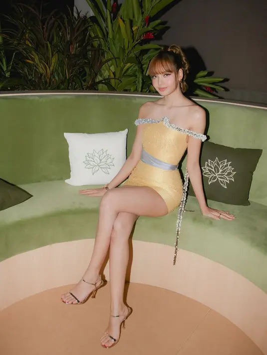 Saat after party, Lisa BLACKPINK tampil glam kenakan off shoulder cocktail dress kuning. Aksen silver line di bagian dada jadi sentuhan mewah pada tampilan Lisa [@lalalalisa_m]