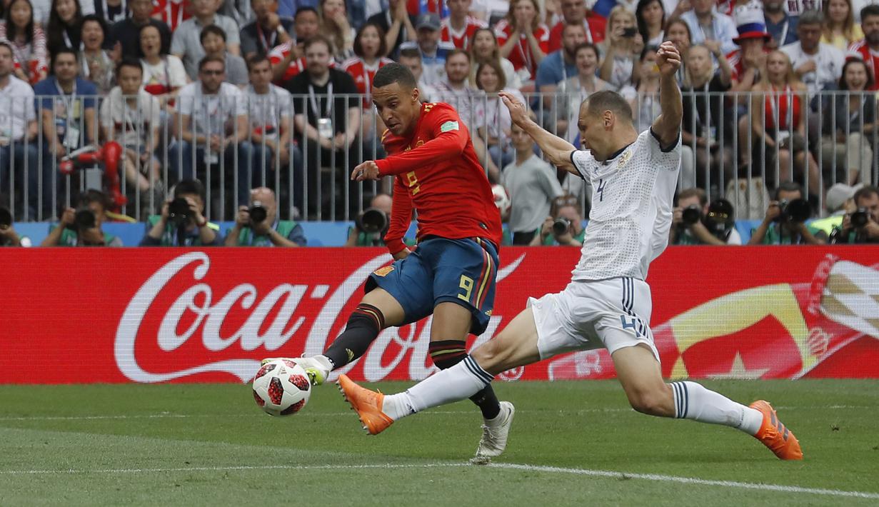 Pemain Spanyol, Rodrigo (kiri) melepaskkan tembakan melewati adangan pemain Rusia, Sergei Ignashevich pada laga 16 besar Piala Dunia 2018 di  Luzhniki Stadium, Moskow, Rusia, (1/7/2018). Rusia menang penalti atas Spanyol Spain 4-3. (AP/Manu Fernandez)