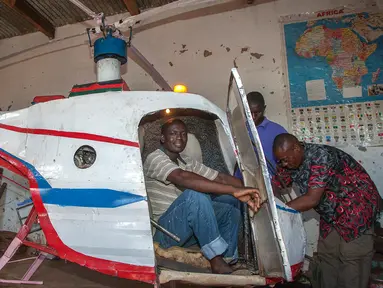 Felix Kambwiri duduk di kokpit helikopter buatannya di garasi rumahnya di Desa Gobede, Malawi, 19 Februari 2016. Helikopter yang dikerjakan sejak empat bulan lalu itu dibuat dari rongsokan besi tua dan fiberglass. (Amos Gumulira/AFP)