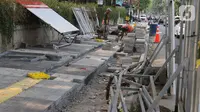 Pekerja mengerjakan proyek revitalisasi trotoar di kawasan Kemang, Jakarta Selatan, Selasa (15/10/2019). Pemerintah Provinsi DKI menargetkan pelebaran dan penataan trotoar ini akan rampung pada Desember 2019. (Liputan6.com/Herman Zakharia)