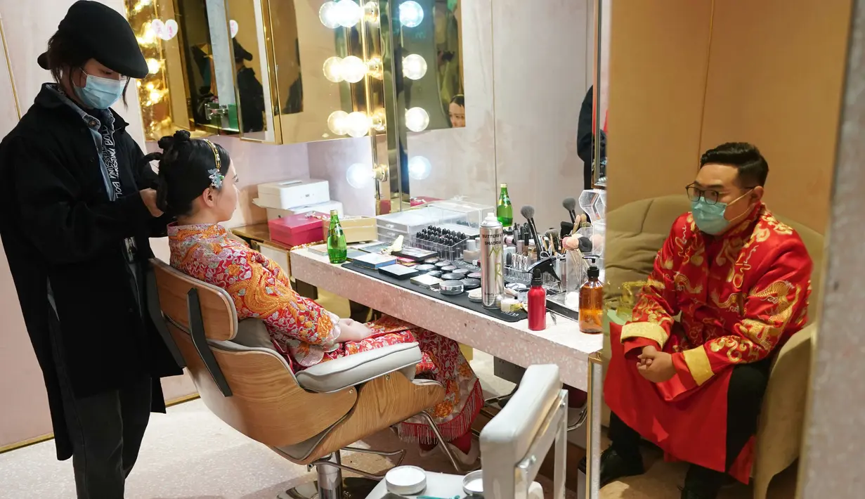 Sepasang calon pengantin bersiap untuk pemotretan foto pranikah di sebuah studio foto di Wuhan, Provinsi Hubei, China tengah, pada 12 April 2020. Warga Wuhan kembali melakukan persiapan pernikahan setelah meredanya pandemi corona Covid-19. (Xinhua/Wang Yuguo)