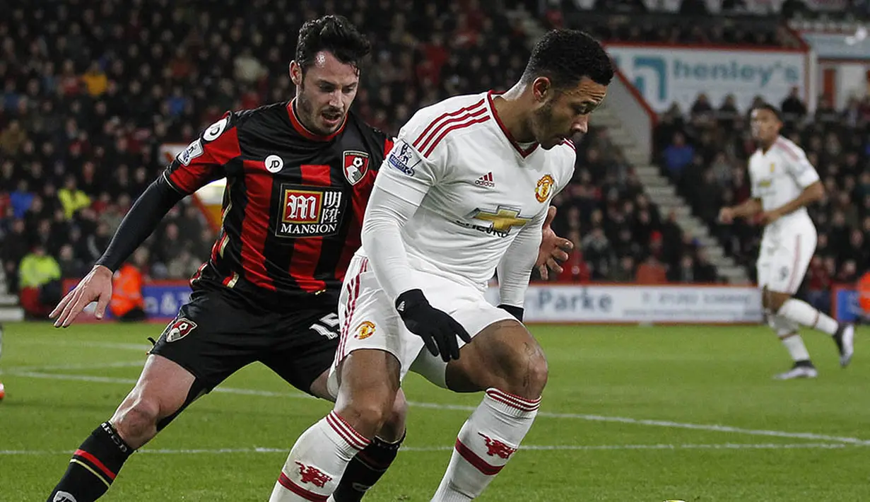Gelandang serang MU, Memphis Depay, berusaha melewati hadangan bek Bournemouth, Adam Smith, pada laga Liga Premier Inggris di Stadion Vitality, Inggris, Sabtu (12/12/2015). (AFP/Ian Kington)