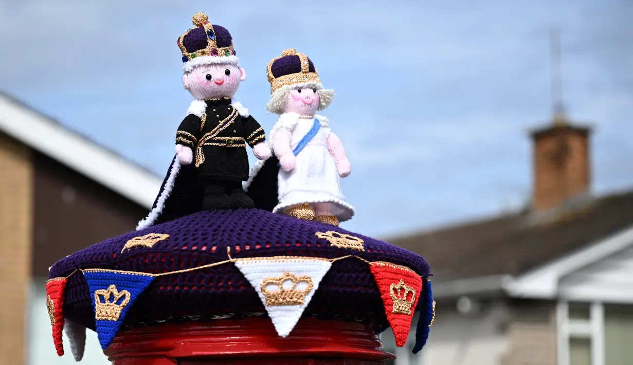 Foto yang diambil pada 2 Mei 2023 menunjukkan rajutan Raja Charles III dan Permaisuri Camilla yang dipajang di kotak pos di sebelahnya, di Rhyl, Wales utara, menjelang upacara penobatan. (Photo by Paul ELLIS / AFP)