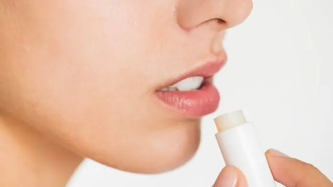 Seorang perempuan menggunakan produk lip balm untuk merawat bibirnya (Foto Dok: Freepik/rawpixel.com)