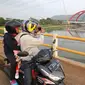 Warga mengabadikan kendaraan pemudik yang melintasi Jembatan Kali Kuto di ruas tol fungsional Batang-Semarang, Gringsing, Jateng, Rabu (13/6). Berfungsinya Jembatan ini akan memperlancar arus mudik dan arus balik Lebaran 2018. (Liputan6.com/Arya Manggala)