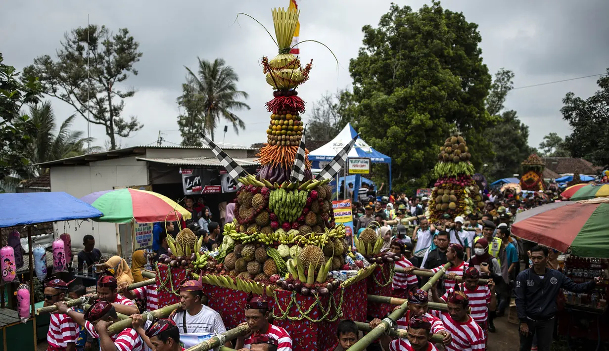 Para peserta mengarak tumpeng durian selama festival Kenduren di Jombang, Jawa Timur, Minggu (3/3). Festival tersebut merupakan acara tahunan yang digelar setiap memasuki musim panen durian sebagai bentuk syukur petani kepada Tuhan (Juni Kriswanto/AFP)