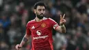 Jelang waktu turun minum atau pada menit ke-45+2, tendangan keras Bruno Fernandes berhasil merobek jala gawang Arsenal. Manchester United unggul 1-0. (Paul ELLIS/AFP)