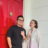 Rianti Cartwright tampil dengan kebaya putih panjang dengan aksen bordiran dipadukan celana pink dan sandal hitam. [@riantic]