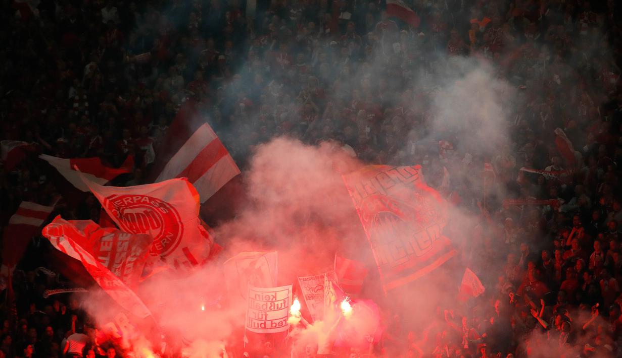 Suporter Bayern Munchen menyalakan flare saat merayakan gelar juara DFB Pokal setelah mengalahkan RB Leipzig di Stadion Olympic, Berlin, Sabtu (25/5). Munchen menang 3-0 atas Leipzig. (AFP/Odd Andersen)