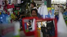 Orang-orang berjalan melalui pasar loak di Maracaibo, Venezuela, Senin, 22 Juli 2024. Venezuela telah mengumumkan akan mengadakan pemilihan presiden pada 28 Juli – beberapa bulan lebih awal dari perkiraan. (AP Photo/Matias Delacroix)