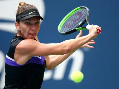 Petenis Rumania, Simona Halep melakukan pukulan ke arah Nicole Gibbs dari Amerika Serikat pada babak pertama AS Terbuka 2019 di USTA Billie Jean King National Tennis Center, Selasa (27/8/2019). Juara Wimbledon itu meraih kemenangan 6-3 3-6 6-2 atas Nicole Gibbs. (Clive Brunskill/Getty Images/AFP)