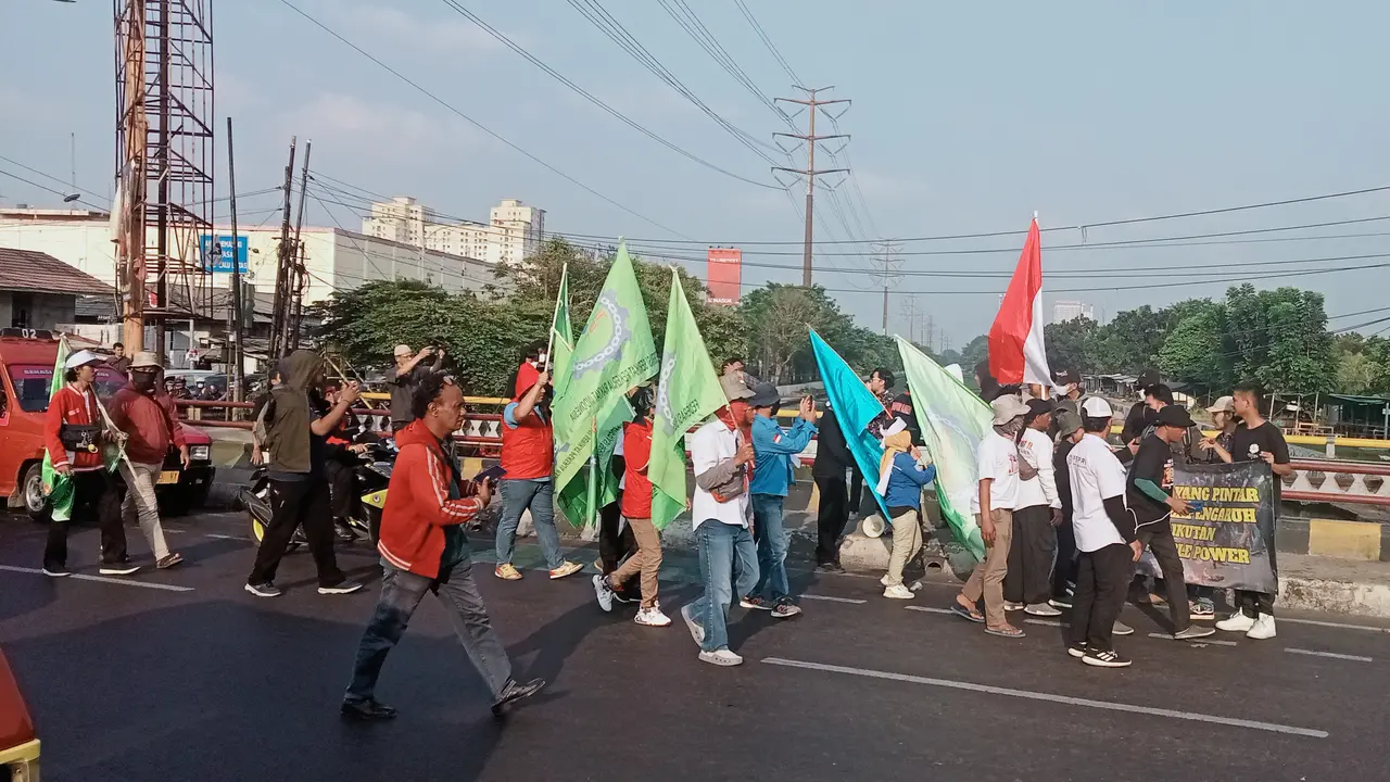 Massa pemuda di simpang Kampus UNISMA 45, Jalan Raya Cut Mutia, Bekasi Timur, Kota Bekasi, menolak aksi buruh yang hendak berdemo ke Jakarta. Foto: Liputan6.com/Bam Sinulingga