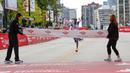 Pelari Kenya, Kelvin Kiptum melakukan selebrasi menjelang garis finis saat Chicago Marathon 2023 di Chicago, Illinois, Amerika Serikat, 8 Oktober 2023. (AFP/Kamil Krzaczynski)