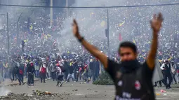 Demonstran saat bentrok dengan polisi anti huru hara di Quito (7/10/2019). Demonstran juga menuntut pemerintah membatalkan pemindahan pemerintah keluar dari ibu kota. (AFP Photo/Martin Bernetti)