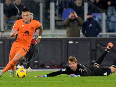 Pemain Inter Milan, Lautaro Martinez (kiri) berusaha melewati kiper Lazio, Ivan Provedel pada laga lanjutan Liga Italia 2023/2024 di Olympic Stadium, Roma, Italia, Senin (18/12/2023) dini hari WIB. (AFP/Andreas Solaro)