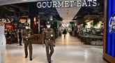 Polisi Thailand berpatroli di dalam pusat perbelanjaan Siam Paragon sebelum dibuka di Bangkok pada tanggal 4 Oktober 2023, sehari pasca penembakan yang menewaskan dua orang. (Lillian SUWANRUMPHA/AFP)