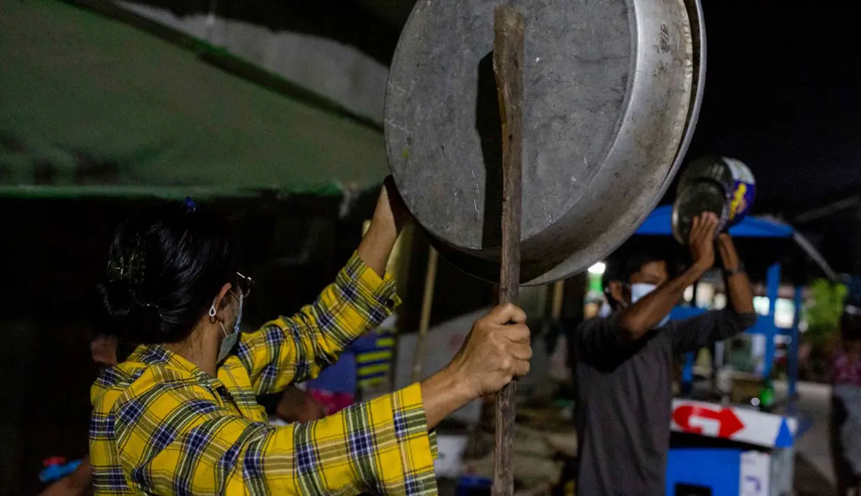 Warga memukul kaleng, panci, dan wajan untuk membuat keributan memprotes kudeta militer di Yangon, Myanmar, 2 Februari 202. Militer Myanmar menolak kemenangan telak NLD dalam pemilihan umum pada 8 November lalu dengan tuduhan penipuan yang tidak berdasar. (STR/AFP)