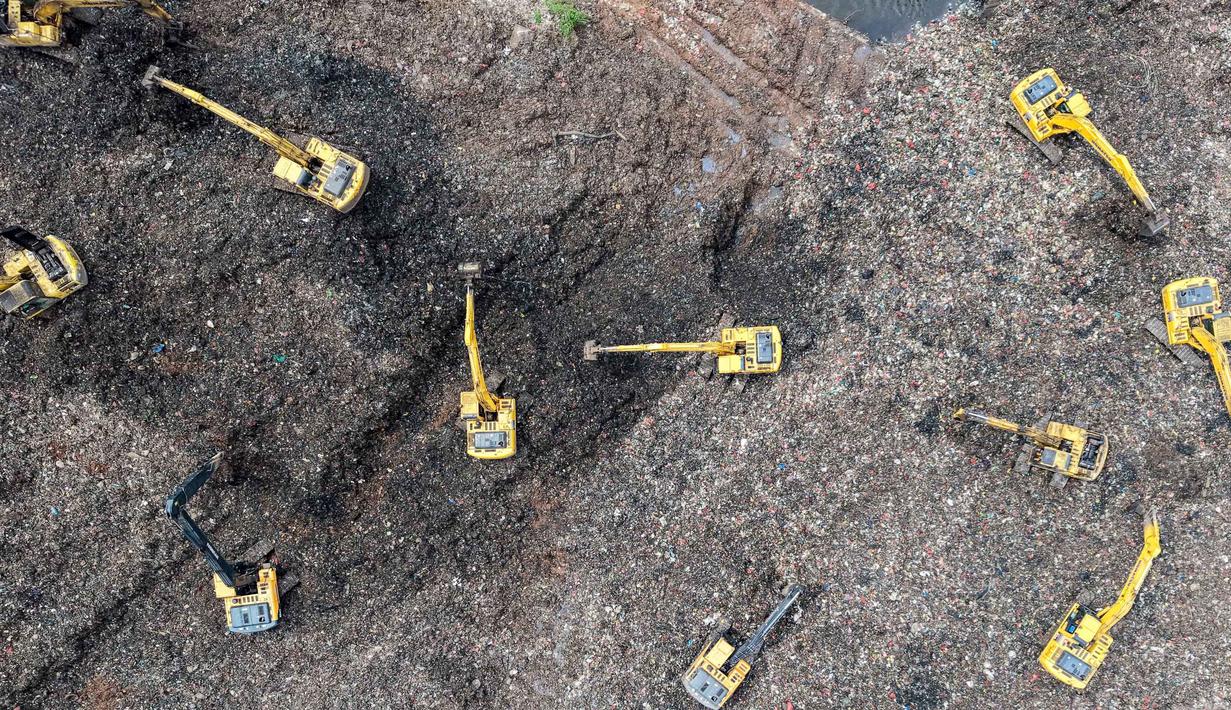 Hingga kini, total korban tercatat 13 orang dengan rincian, enam meninggal dunia, enam selamat, dan satu lainnya masih dalam pencarian. Tampak foto udara menunjukkan tim penyelamat menggunakan alat berat untuk mencari korban longsor di Tempat Pembuangan Sampah Terpadu (TPST) Bantargebang, Kota Bekasi, Jawa Barat, pada Senin 9 Maret 2026. (BAY ISMOYO/AFP)