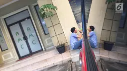 Seorang pria beristirahat di teras Klinik Azzahra Medical Center, Jakarta, Jumat (10/11). Tak ada garis polisi terpasang usai peristiwa dokter Letty Sultri yang tewas ditembak suaminya sendiri, dokter Helmi di klinik itu. (Liputan6.com/Immanuel Antonius)
