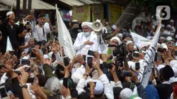 Rizieq Shihab menyapa massa pendukungnya saat tiba di kediamannya di Jalan Petamburan, Jakarta, Selasa (10/11/2020). Rizieq Shihab tiba di kediamannya usai pulang dari Arab Saudi. (merdeka.com/Imam Buhori)