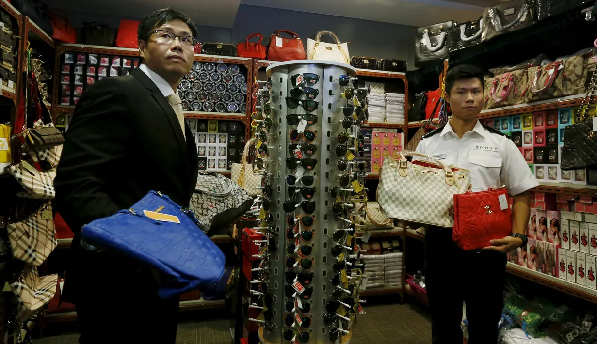 Petugas memperlihatkan sejumlah barang palsu di Kantor Bea Cukai Hong Kong, Kamis (6/8). Lebih dari 30.000 barang disita dari satu warga Filipina dan dua warga Pakistan yang merupakan sindikat penjual barang yang diduga palsu. (REUTERS/Bobby Yip)