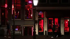 Orang-orang berjalan melewati rumah bordil di Red Light District Amsterdam, Belanda, Rabu (3/4). Red Light District merupakan kawasan prostitusi yang tersohor dan menjadi salah satu destinasi wisata di Belanda. (REUTERS/Yves Herman)