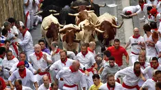 Peserta bersuka ria berlari di samping banteng selama Festival San Fermin di Pamplona, Spanyol, Senin (9/7). Festival berbahaya ini diikuti oleh peserta dari seluruh penjuru dunia. (AP Photo/Alvaro Barrientos)
