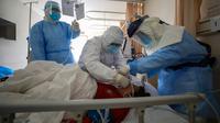 Pekerja medis memberikan perawatan kepada pasien virus corona atau COVID-19 di sebuah rumah sakit di Wuhan, Provinsi Hubei, China, Minggu (16/2/2020). Hingga saat ini terkonfirmasi 70.548 orang terinfeksi virus corona di China Daratan. (Chinatopix via AP)