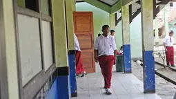 Arya Permana berjalan di SDN Cipurwasari 1 kawasan Karawang, Jawa Barat, Selasa (9/4). Arya Permana diketahui memiliki berat badan hingga 192 kg, sekarang sudah turun 105 kg menjadi 87 kg pasca operasi lambung. (Liputan6.com/Herman Zakharia)