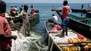 Gambar 5 Oktober 2018, menunjukkan nelayan menyiapkan jaring mereka di pulau Migingo, Danau Victoria. Sebagian besar penduduk di pulau yang tidak ditampilkan di beberapa peta ini bermata pencaharian sebagai nelayan dan pedagang ikan. (Yasuyoshi CHIBA/AFP)