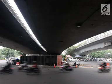 Kendaraan melintas di dekat lokasi tergulingnya truk kontainer di kolong flyover Tomang, Jakarta, Kamis (28/6). Truk kontainer bernomor polisi BN 4706 BP tersebut terguling saat hendak berbelok arah ke Jalan Tomang Raya. (Merdeka.com/Iqbal S. Nugroho)