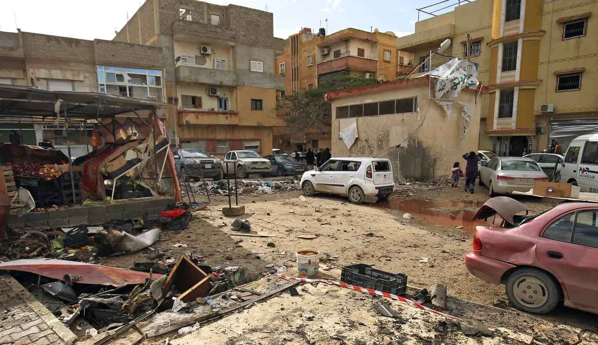 Dampak kerusakan serangan bom mobil ganda di Kota Benghazi, Libya, Rabu (24/1). Serangan ganda itu terjadi dalam rentang waktu yang berdekatan, sekitar 10-15 menit antara masing-masing kejadian. (AFP PHOTO/Abdullah DOMA)