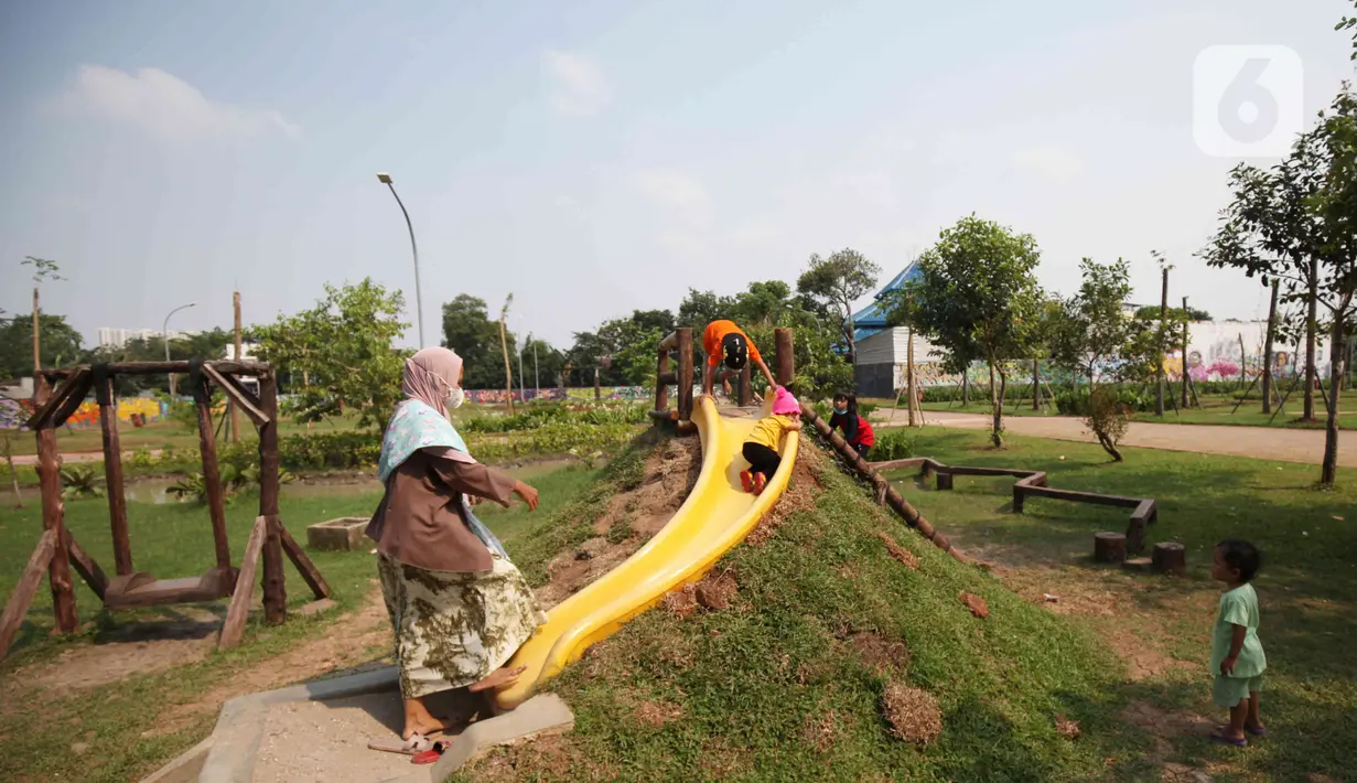 Anak-anak bermain wahana permainan di dalam kawasan Taman Jalur Hijau Kosambi, Jakarta Barat, Sabtu (8/1/2022). Di taman ini bukan hanya ruang terbuka hijau yang sangat bagus untuk berswafoto tetapi juga terdapat berbagai hewan untuk mengedukasi anak-anak yang datang. (Liputan6.com/Angga Yuniar)