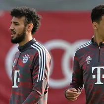 Gelandang Bayern Munchen, Jamal Musiala (kanan) dan bek Noussair Mazraoui menghadiri sesi latihan di Munich, Jerman selatan, pada 31 Oktober 2022. Laga ini bisa dibilang sebagai laga formalitas belaka. Sebab, apa pun hasilnya takkan memengaruhi posisi mereka. (AFP/Christof Stache)