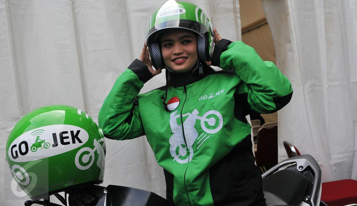 Seorang wanita memakai pakaian lengkap Go-Jek  beserta helm usai diterima sebagai pengendara Go-Jek  di Hall A Basket Senayan, Jakarta, Jumat (14/8/15). Fenomena ojek online dengan aplikasi di hanphone kini banyak diminati. (Liputan6.com/Herman Zakharia)