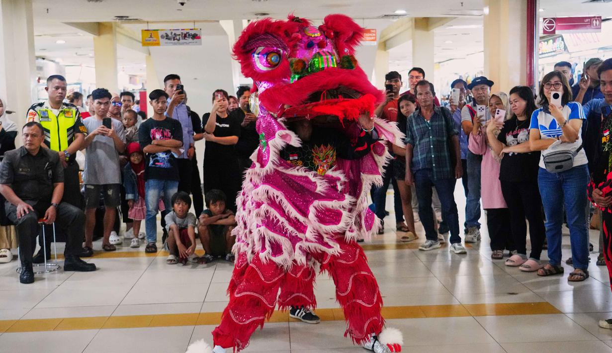 Aksi para penari dengan kostum berwarna cerah dan gerakan lincah menghibur pengunjung yang memadati area Pusat Perbelanjaan Senen, Jakarta. Tampa dalam foto, seorang penari barongsai tampil di Pusat Perbelanjaan Senen, Jakarta, Kamis 12 Februari 2026. (AP Photo/Tatan Syuflana)