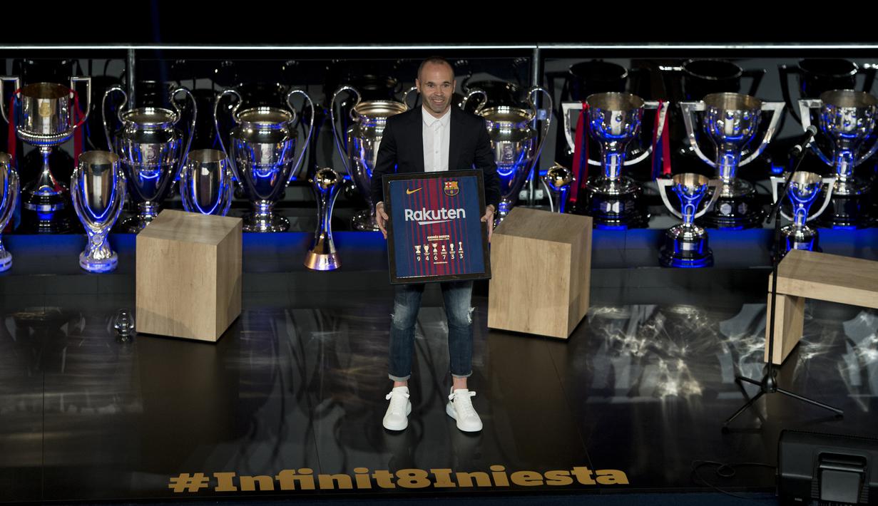 Gelandang Barcelona, Andres Iniesta, berpose dengan deretan trofi yang pernah diraihnya saat berada di Stadion Camp Nou, Barcelona, Jumat (18/5/2018). Semua gelar bergengsi pernah dipersembahkan Iniesta untuk La Blaugrana. (AFP/Josep Lago)
